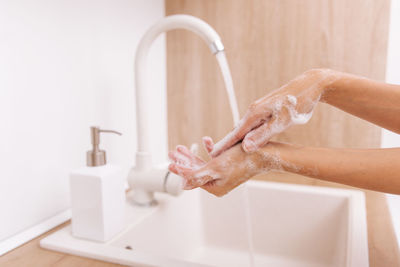 Cropped hand of woman cleaning hands