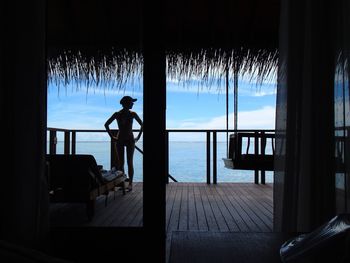 Silhouette of person sitting on chair in sea