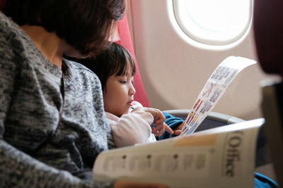 Man looking at daughter sitting in airplane