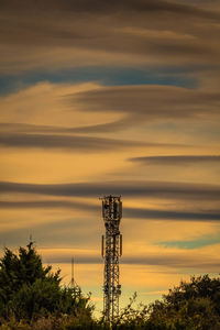 Low angle view of communications tower against sky during sunset