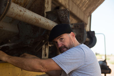 Portrait of adult man standing near a train