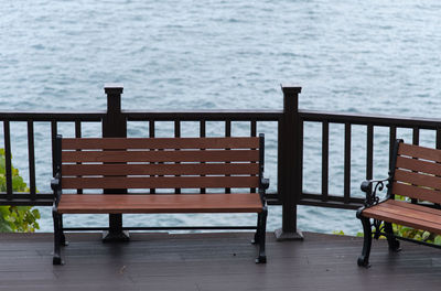 Empty chairs and table by sea
