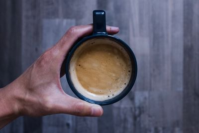 Close-up of hand holding coffee cup