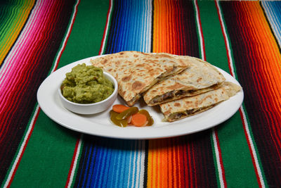 A delicious cheese and beef quesadilla on a plate.