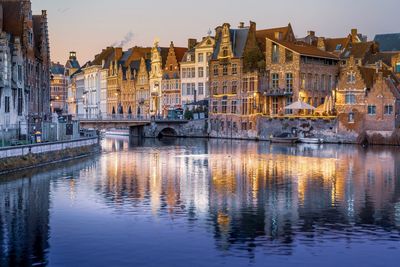 Reflection of buildings river at dusk