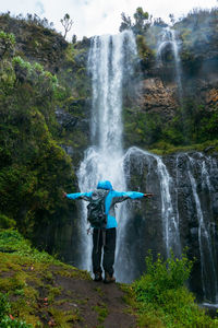Rear view of hiker against a nithi waterfall in chogoria route, mount kenya national park, kenya