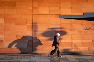 Full length of a woman walking on footpath