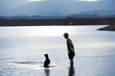 Man with dog in shallow water