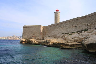 Lighthouse on building by sea