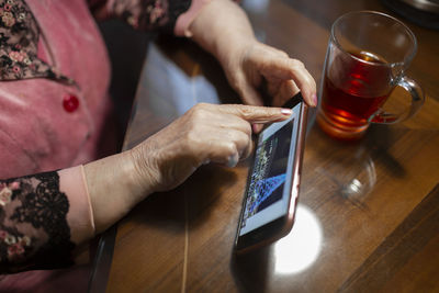 Midsection of man using laptop on table