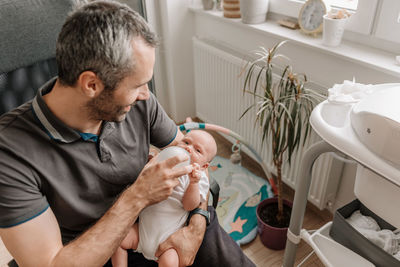 Father feeding baby with bottle of baby formula