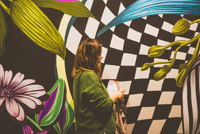 Woman standing against pattern wall