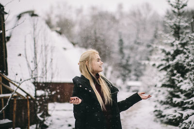 Woman with arms raised standing in snow