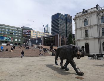 People walking on street against buildings in city