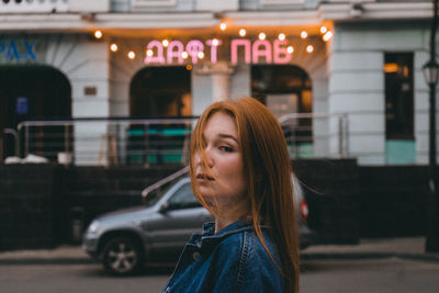 Portrait of woman standing against bus