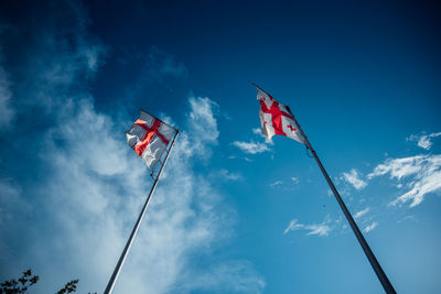 Low angle view of flags against sky