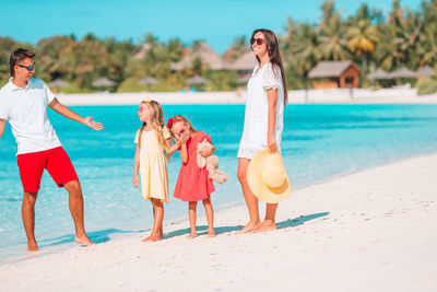 Cheerful family standing on beach