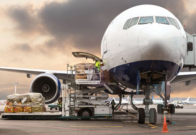 Airplane on airport runway against sky