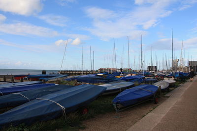 Boats moored at harbor against sky