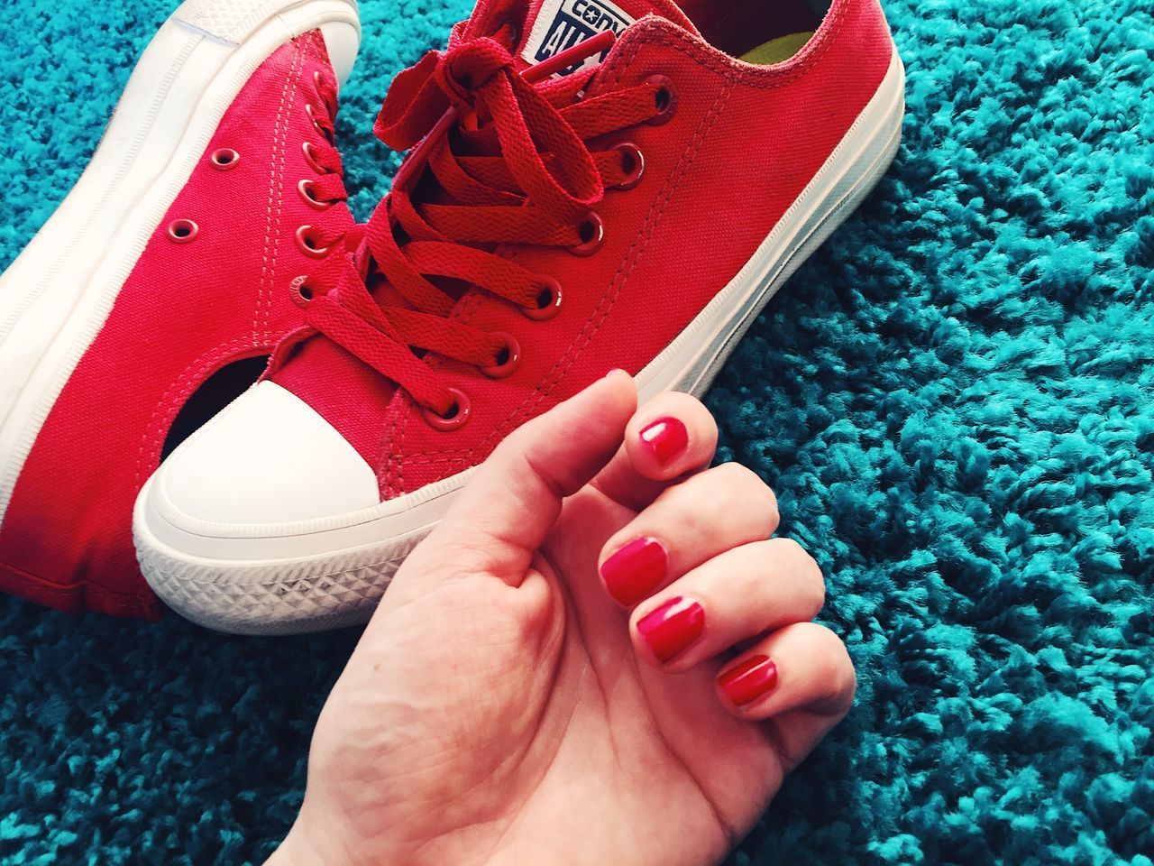 LOW SECTION OF WOMAN WEARING RED SHOES ON ROCK