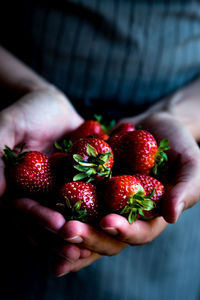 Midsection of person holding strawberries