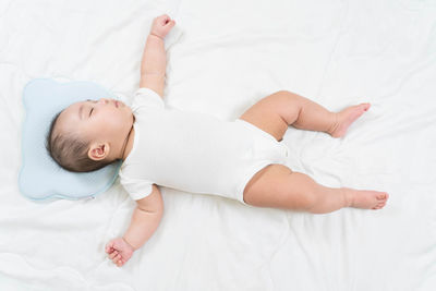 High angle view of baby lying on bed