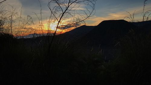 Scenic view of silhouette mountain against sky at sunset