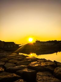 Scenic view of river against orange sky