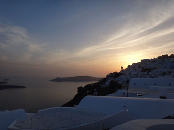 Scenic view of sea and buildings against sky during sunset