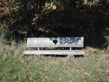 Empty bench on field in park