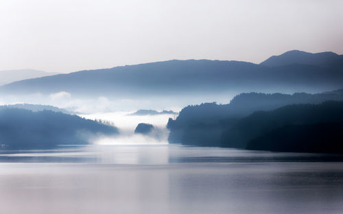 Scenic view of lake and mountains against sky