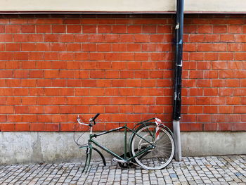 Bicycle leaning against brick wall