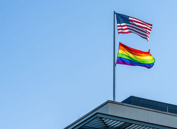 Low angle view of rainbow and us flag  against clear blue sky