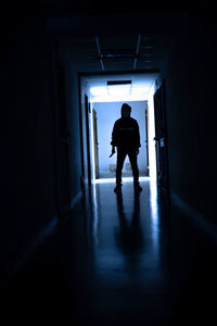 Rear view of silhouette man walking in corridor of building