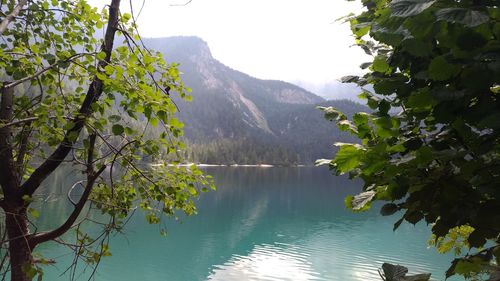 Scenic view of lake by tree mountains against sky