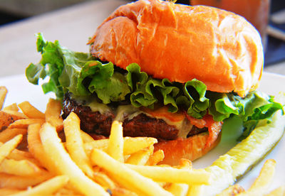 Close-up of fresh hamburger and french fries served on table at restaurant