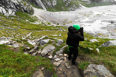 Rear view of man standing on mountain during winter