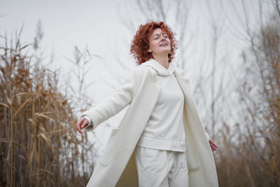 Pretty young woman in trendy white clothes poses in motion