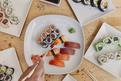 She close up of hands taking a piece of sushi with chopsticks. healthy seafood