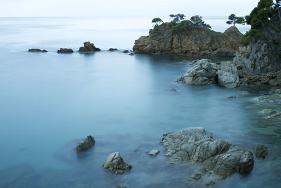 Rocks in sea against sky