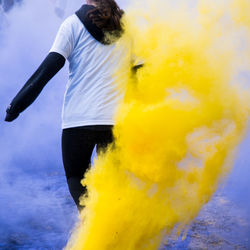 Low section of woman walking amidst powder paint during holi