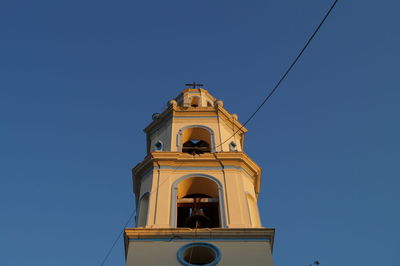 Low angle view of bell tower against blue sky