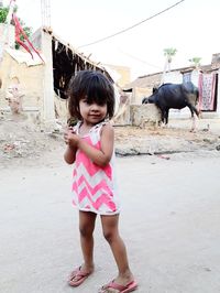 Full length of cute girl standing against pink wall