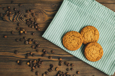 Directly above shot of cookies by coffee beans on table