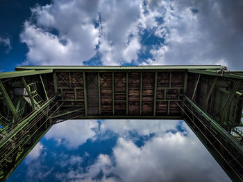 Low angle view of bridge against cloudy sky