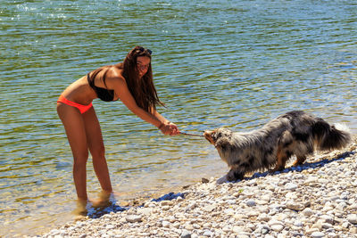 Full length of young woman standing on beach