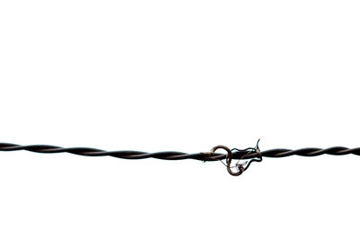 Close-up of barbed wire against sky