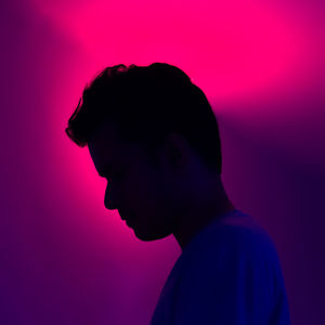 Close-up portrait of silhouette man against pink background
