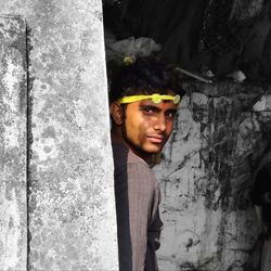 Portrait of young man standing against wall