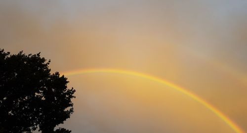 Low angle view of rainbow against sky during sunset